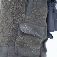 blaser-herren-fleecejacke-sherpa.. Die Blaser Herren Fleecejacke Sherpa in Dunkeloliv verfügt über 2 Frontpattentaschen mit geräuschlosen Druckknöpfen und Munitionsschlaufen sowie 2 Reißverschluss-Brusttaschen. Besätze im Vintage-Look an Schultern, Armen, Saum und Taschen bieten edlen Look. Schneeflocken sind auf dem Bild zu sehen.