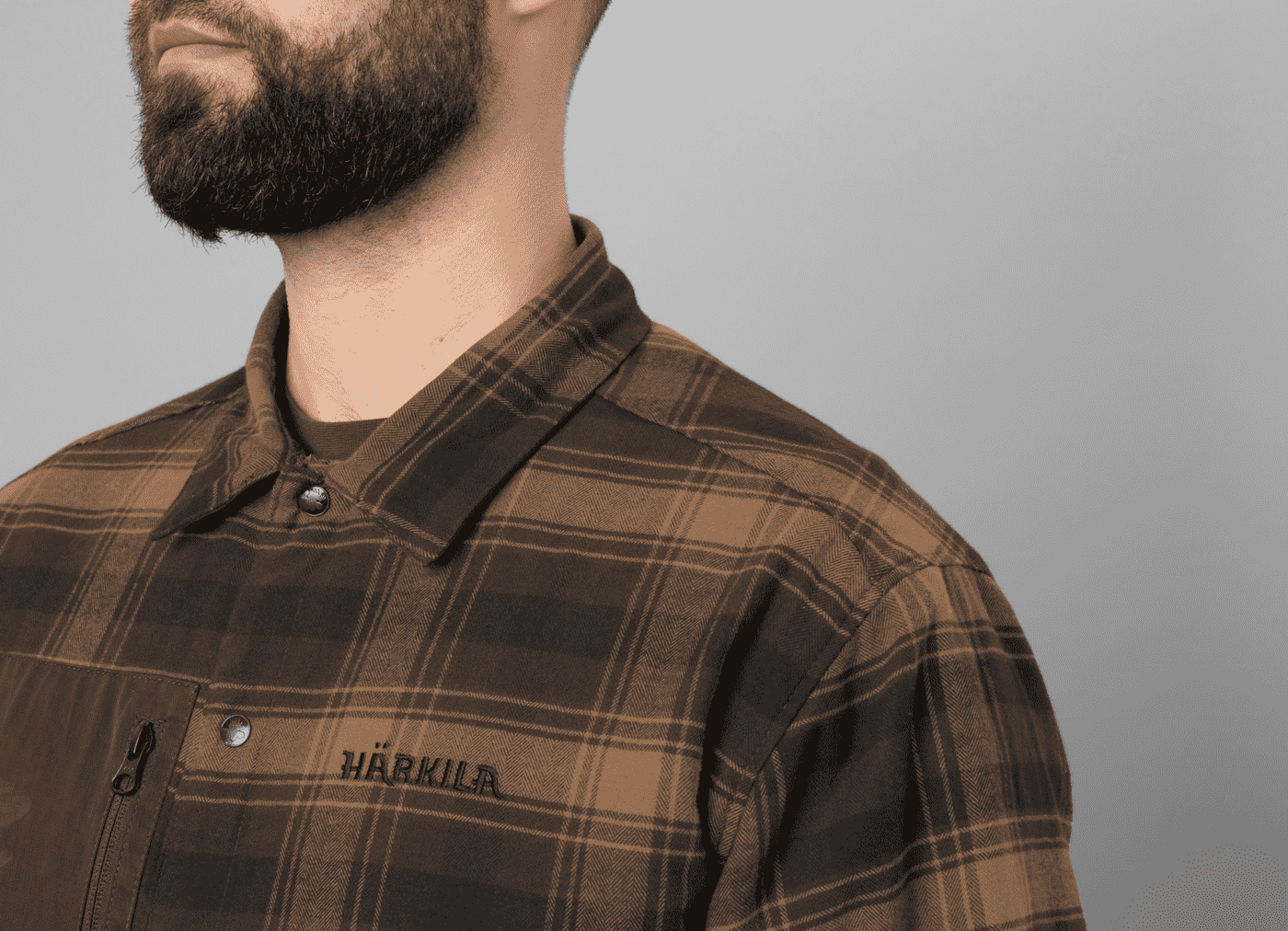 haerkila-hemdjacke-eirik-wendbar (4) Eine Härkila Hemdjacke Eirik in Karomuster zum Wenden mit langen Ärmeln, Brusttasche und Druckknopfleiste. Bild auf weißem Hintergrund.